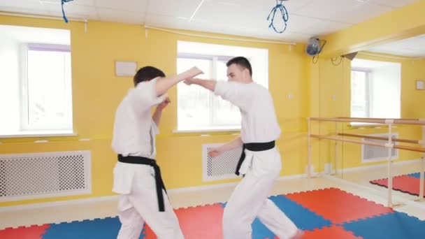 Artes marciales. Dos hombres atléticos entrenando sus habilidades aikido en el estudio. Lanzar al oponente al suelo — Vídeo de stock