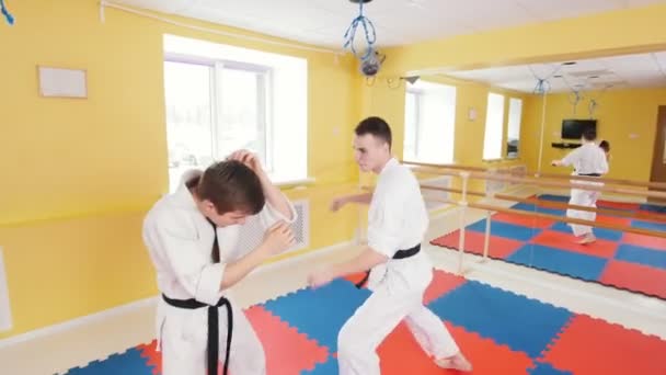 Seni bela diri. Dua pria atletik melatih keterampilan aikido mereka di studio. Menangkap lawan dan melemparkan dia di lantai — Stok Video