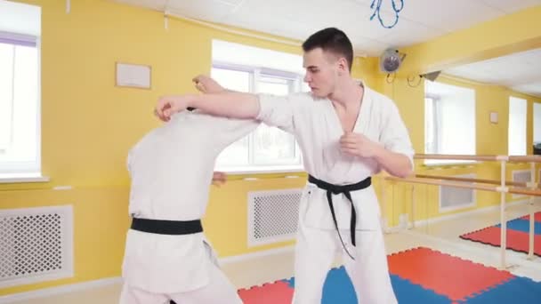 Két sportos férfi képzés az aikido képességeit a stúdióban. Semlegesítő az ellenfelek találatot, és dobott neki a padlón — Stock videók