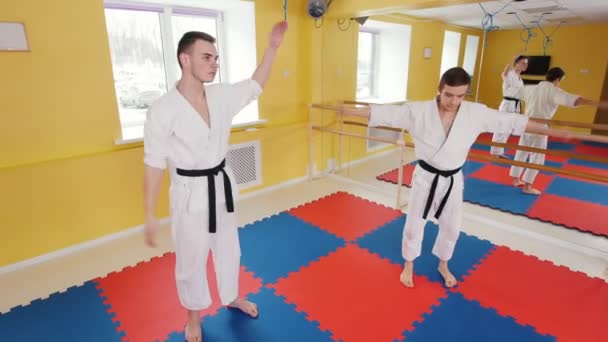 Dos hombres atléticos entrenando sus habilidades aikido en el estudio. Calentamiento antes del entrenamiento — Vídeos de Stock