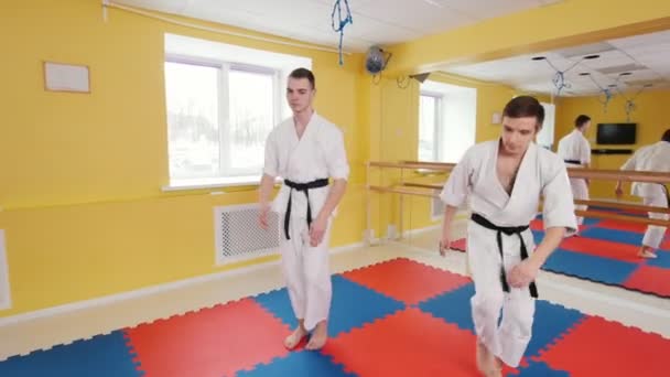 Két férfi képzése az aikido készség a stúdióban. Bemelegítés edzés előtt — Stock videók