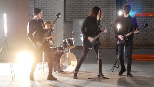 Un grupo de rock con una repetición. Guitarristas vestidos de negro interpretando sus papeles . — Vídeo de stock