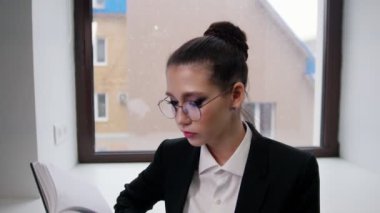 İş konsepti. Genç bir kadın kitap okuyor