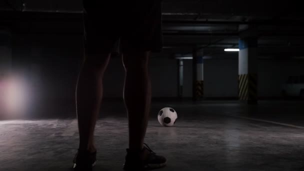 Podzemní parkoviště. Fotbalový muž stojící před míčem — Stock video
