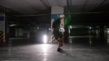 Yeraltı Park yeri. Genç bir futbol adamı topu ile futbol becerilerini eğitim