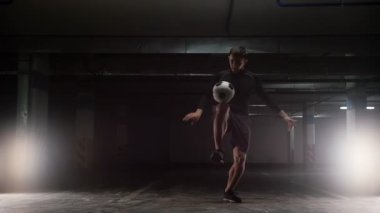 Top ile genç bir futbol adamı eğitim hileler. Sırtında topu Dengeleme