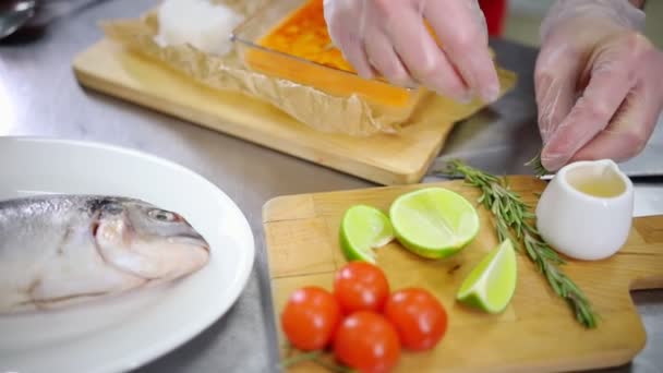 A konyhában dolgozó séf. Díszítik az edényt rozmaringgal — Stock videók