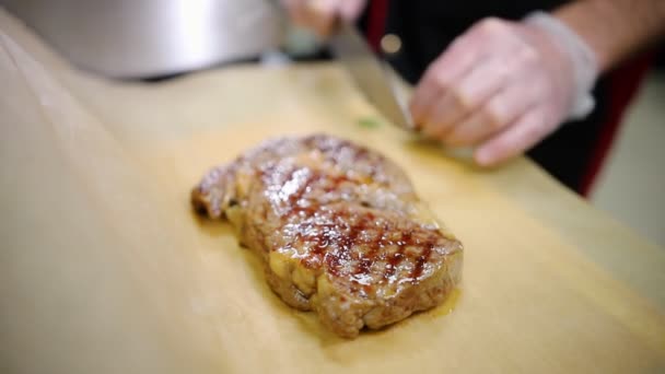 Mutfakta çalışan bir şef. Biberiye ile biftek serpin — Stok video