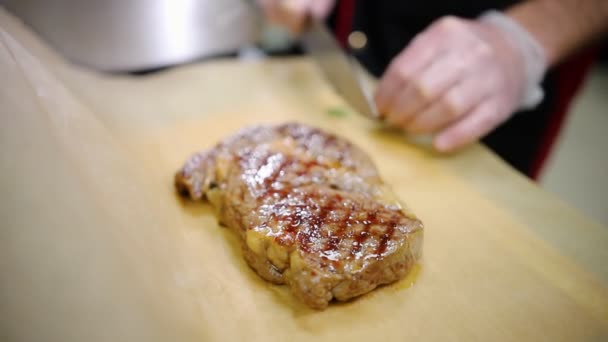 Un chef qui travaille dans la cuisine. Saupoudrer le steak d'un romarin — Video