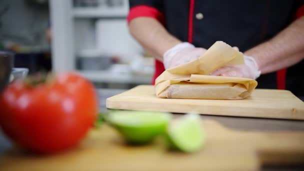 Een chef-kok die in de keuken werkt. Putting de biefstuk in een papier en weg te verplaatsen — Stockvideo