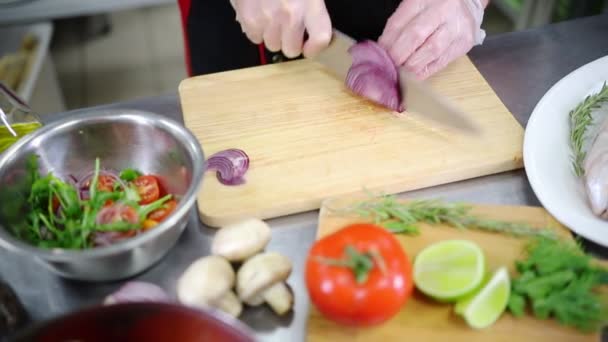 En i köket som skär löken — Stockvideo