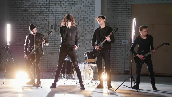 A rock group having a repetition in a garage. Members of a group wearing black clothes — Stock Photo, Image