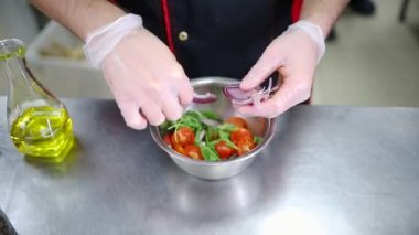 Mutfakta çalışan bir şef. Salata yapıyorum. Soğan ekleyin