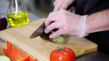 Mutfakta çalışan bir şef. Patlıcan kesme