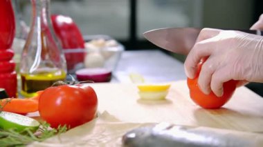 Mutfakta çalışan bir şef. Domates kesme