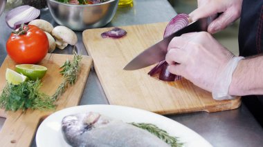 Mutfakta çalışan bir şef. Soğan kesme