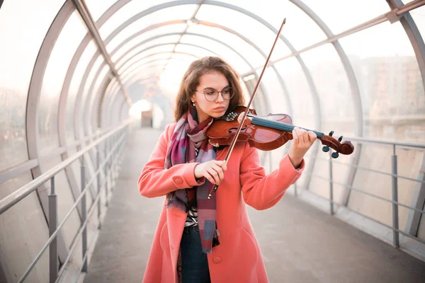 Молодая женщина в очках играет на скрипке — стоковое фото