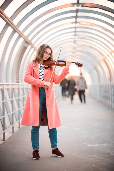 Вдохновлённая молодая женщина, играющая на скрипке в верхнем проходе — стоковое фото