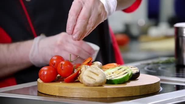 Un chef trabajando en la cocina. Servir verduras fritas en el escritorio — Vídeos de Stock