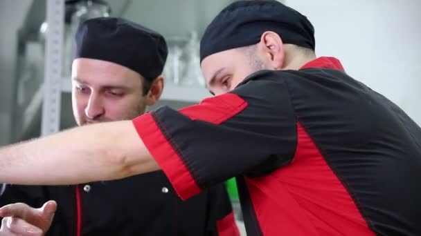 Restoran mutfağı. İki adam yemek servisi üzerinde çalışıyor — Stok video