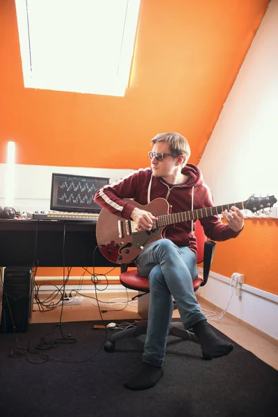 Um homem de óculos a trabalhar com guitarra no estúdio — Fotografia de Stock