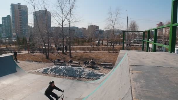 Um homem em uma bicicleta realizando um flip no parque de skate — Vídeo de Stock