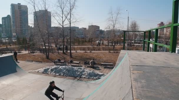 Człowiek na rowerze wykonujący klapę w skateparku — Wideo stockowe