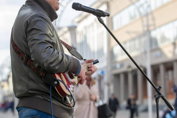 Міські вулиці. Чоловік грає на гітарі на вулицях і співає на мікрофоні — стокове фото
