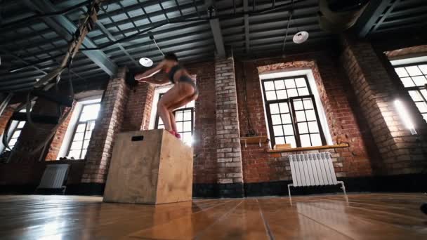 Een atleet vrouw die opwarmt op training. Springen op de doos — Stockvideo