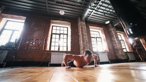 Bir atlet adam atlama ve yukarı itme yapıyor — Stok video