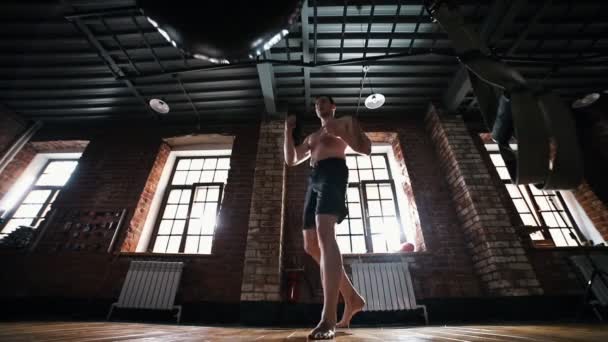 En man boxare sparkar en boxnings påse i gymmet — Stockvideo