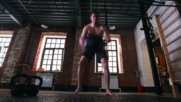 Un hombre atlético tomando un gran peso y dejándolo caer — Vídeo de stock