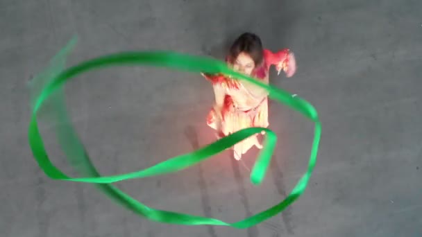 Baletní výcvik uvnitř. Mladá žena baletka tančí a provádí akrobatické prvky držící proužek — Stock video