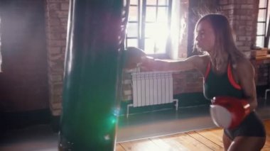 Bir kadın boksör kum torbası isabet