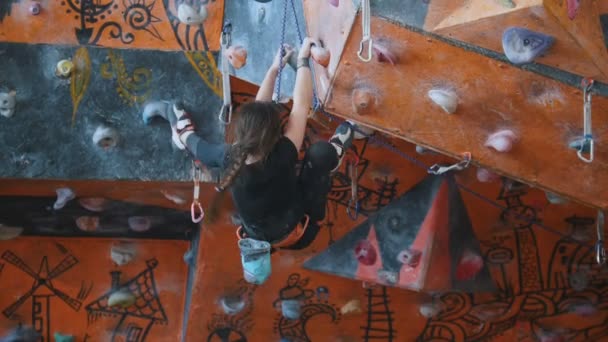 Extrem sport, bouldering. En tonårs flicka klättrar upp på en bergvägg. — Stockvideo