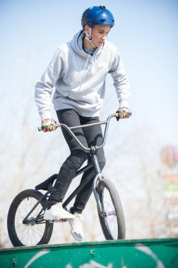 Yarım boruların üstündeki kaykay parkında bisikletli bir adam.