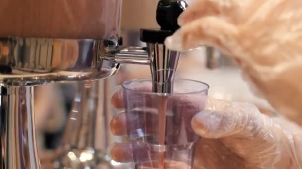 En person som arbetar i buffén. Hälla en drink i plast koppen — Stockvideo