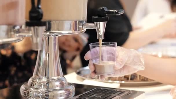 Una persona che lavora nel buffet. Versare un drink nella tazza per degustazione — Video Stock