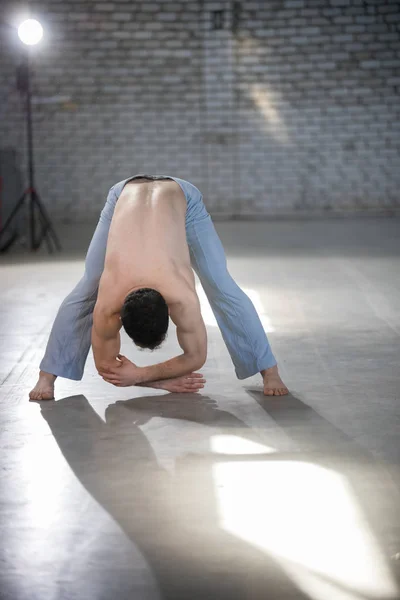 Atletyczny człowiek na szkolenia Capoeira. Gięcie w dół. Rozciąganie kręgosłupa — Zdjęcie stockowe