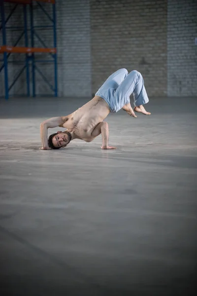 Atletyczny człowiek na szkolenia Capoeira. Stojąc na jednej ręce w nienaturalnych pozach — Zdjęcie stockowe