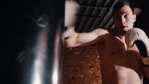 Atletický muž v tělocvičně cviče jeho boxerské dovednosti — Stock video