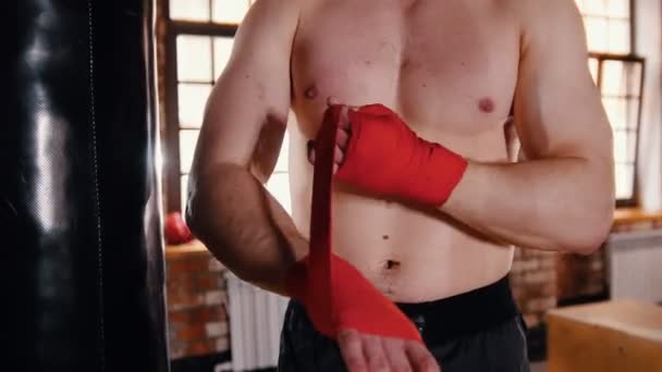 Un homme dans la salle de gym mettant des bandages sur ses mains avant la boxe — Video