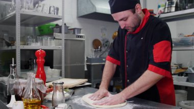 Restoran mutfağı. Pizza için hamur yapan bir şef
