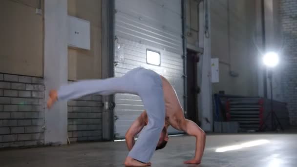 Акробат тренирует свои навыки. Выполнение элементов капоэйры с ногами — стоковое видео