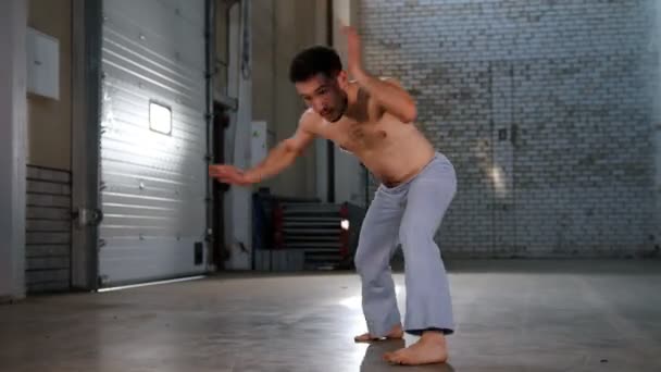 Un hombre acrobático entrenando sus habilidades. Realización de elementos de capoeira de pie sobre las manos — Vídeos de Stock