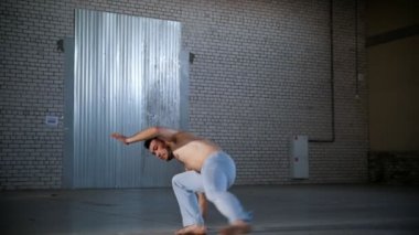 Yeteneklerini eğiten akrobatik bir adam. Capoeira öğelerinin gösterilmesi