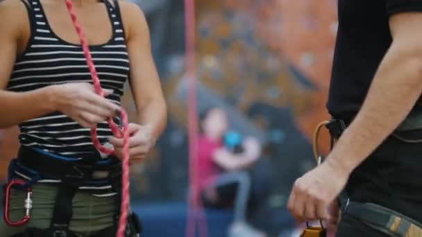 Extreme sport, boulderen. Een vrouw banden de bescherming touwen voor het klimmen onder de coacht instructies — Stockvideo