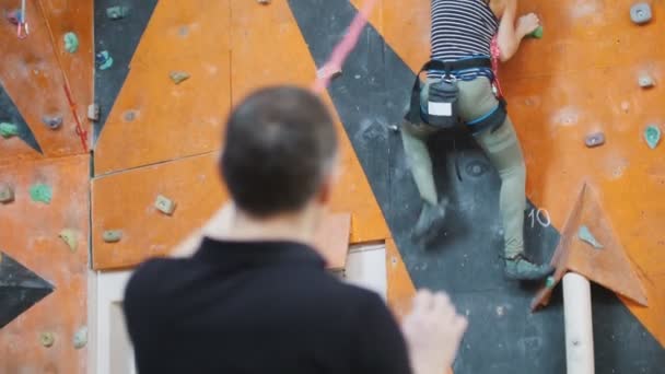 Bouldering. Un entrenador observando a la mujer escalando — Vídeos de Stock