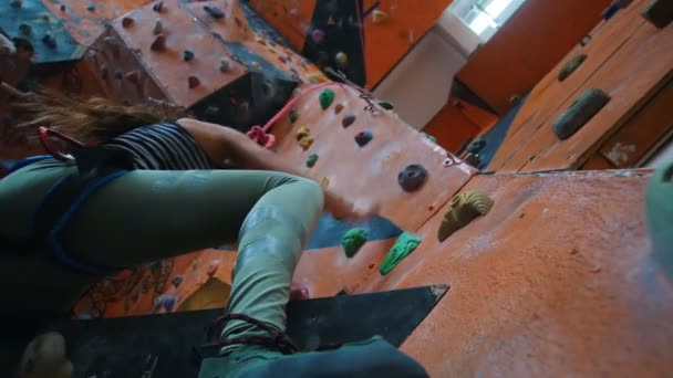 Bouldering. Žena šplhá po skalnaté stěně uvnitř — Stock video