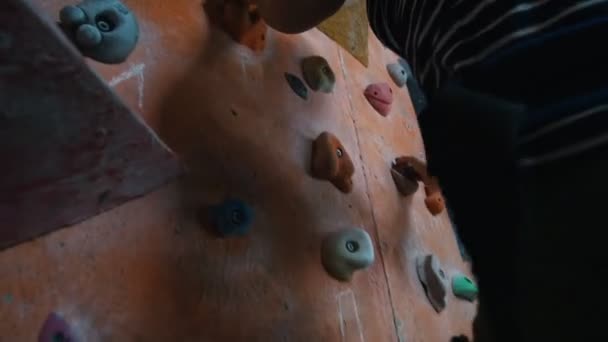 Bouldering. Κέντρο ψυχαγωγίας. Μια γυναίκα που σκαρφαλώνει επιμελώς σε ένα βραχώδες τοίχο — Αρχείο Βίντεο